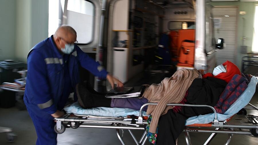 Медицинский сотрудник с пациентом у приемного отделения городской клинической больницы № 15 им. О.М. Филатова                                                                                                                   Фото: ТАСС/Сергей Бобылев
