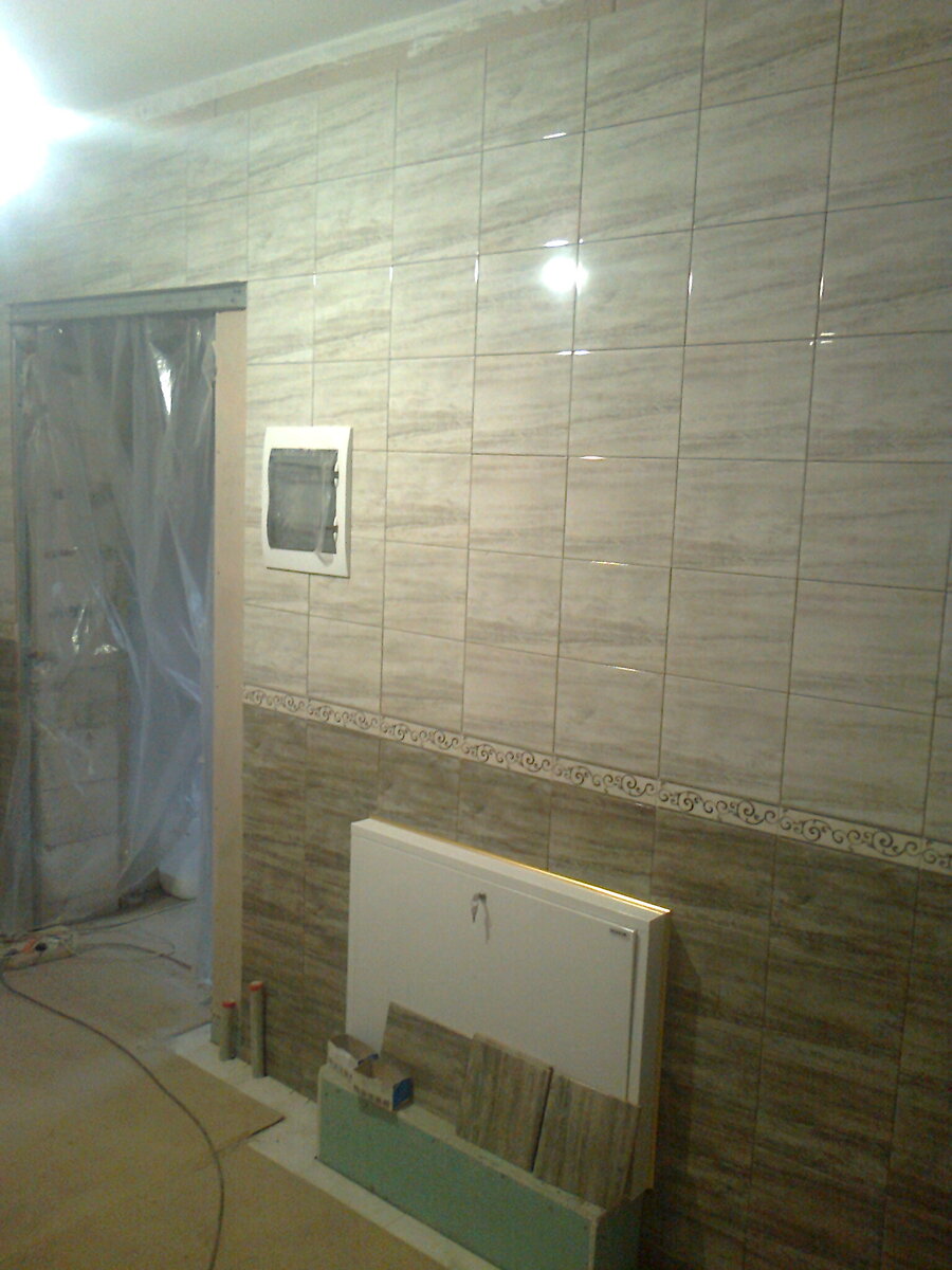 Настенная плитка двух видов разделена декоративным элементом.