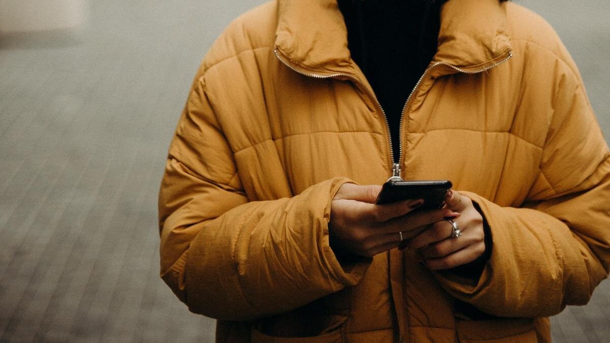    Девушка в желтой куртке с телефоном:pexels.com