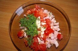 ШАГ 2:
Зелень мелко рубим, помидоры режем кубиками, чеснок пропускаем через чеснокодавилку. Отправляем это все в емкость с сосисками.