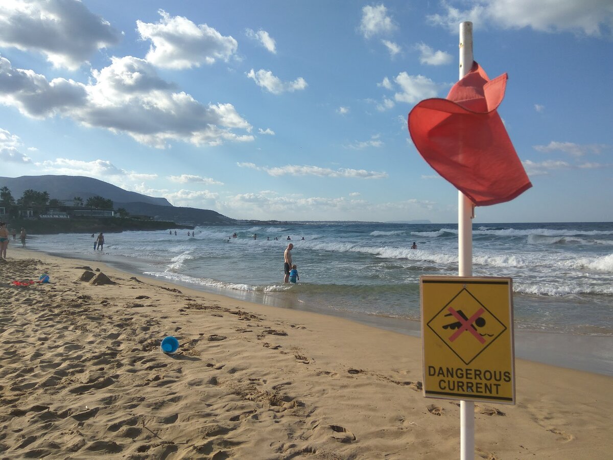 Это пляж на Крите. Флаг красный. Купаться запрещено. Но посмотрите, сколько в воде людей. Фото Светы Давыдовой