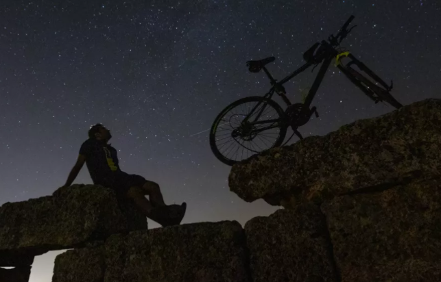 Велосипедист наблюдает зрелище над замком Зерзеван в Турции, 12 августа 2021 года