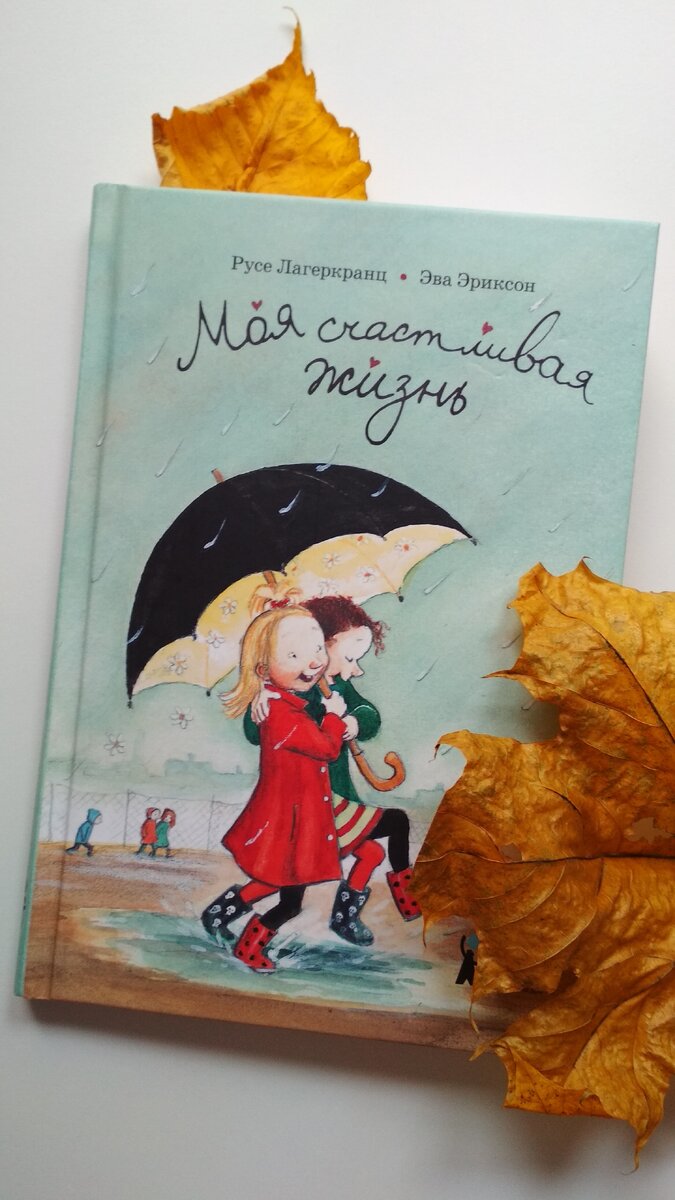 Фото автора. Обложка книги «Моя счастливая жизнь» авторов Русе Лагенкранц, Эва Эриксон. Закладка-осень... Обложка книги красноречиво показывает, что девочкам вместе любой дождь нипочем. Зонтик ярко-желтый внутри - свидетельство теплой, солнечной атмосферы. У ребенка возникает понимание,  что в школе обязательно найдешь друга. 