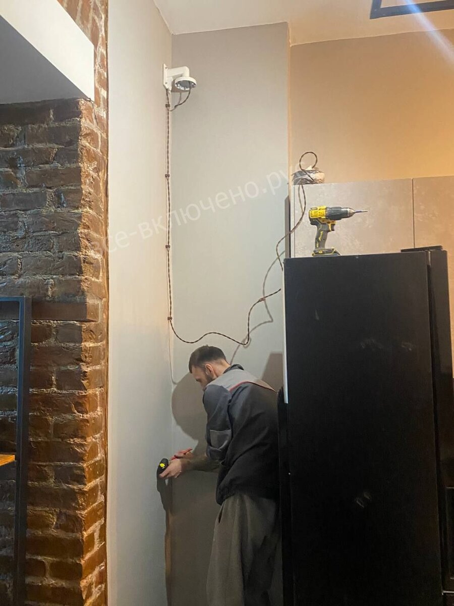 Процесс установки камеры видеонаблюдения. Для питания используется ретро-кабель.
