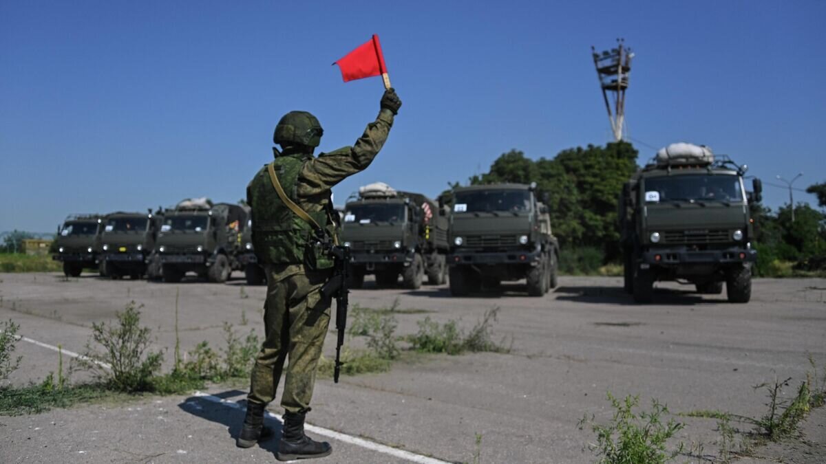    Военнослужащий подает сигналы флажком для проезда военной техники на территории аэропорта Мариуполя© РИА Новости / РИА Новости