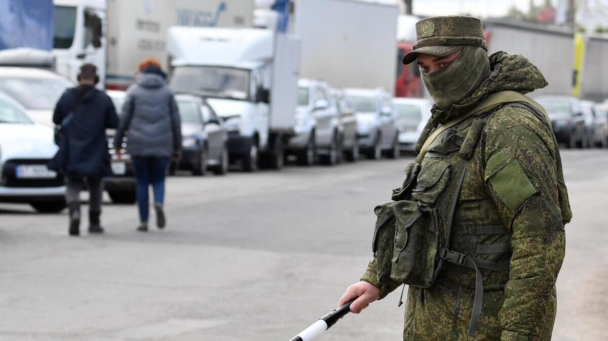 Сотрудник военной полиции регулирует движение в очереди на переправу во время эвакуации из Херсона© РИА Новости / Евгений Биятов
