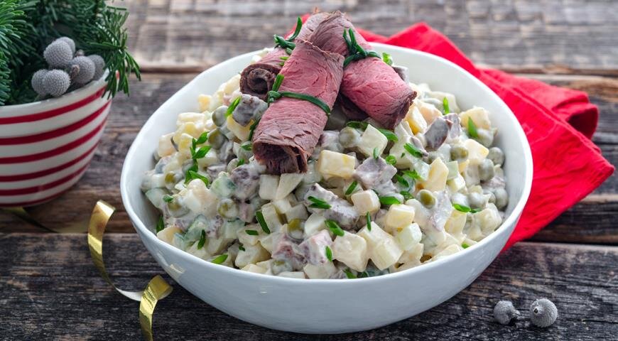 Оливье с мясом, точнее с ростбифом, у каждого за столом вызовет вполне справедливый вопрос: «А что сегодня за праздник?». Действительно, это блюдо сильно отличается от традиционного варианта именно за счет главного ингредиента. Все-таки ростбиф — это особая история! Но, согласитесь, радовать близких чем-то вкусненьким можно не только в праздник. Тем более, что все остальные ингредиенты оливье с мясом вполне демократичные. Однако мы уверены: такой вариант салата вам понравится настолько, что, когда речь зайдет, например, о застолье новогоднем, вы точно запланируете поход в магазин за правильным отрубом.