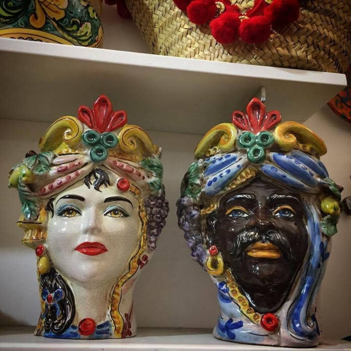 Около 1000 года н.э., когда в Сицилии господствовали мавры, в арабском квартале Палермо “Al Hàlisah”(что значит “правильный” или “лучший”, ныне зовётся Кальса)проживала прекрасная одинокая девушка, любившая сидеть у окна и заниматься растениями на балкончике. В один прекрасный день, проходящий мимо молодой Мавр заметил её на этом балконе, обставленном цветами и моментально влюбился. Он не смог сдержать свои чувства, и поэтому, не медля ни минуты, рассказал ей о своей любви. Девушка, поражённая его признанием, ответила взаимностью на чувства смелого поклонника.
Однако юноша хранил в сердце страшную тайну: на самом деле дома, на востоке, его ждали жена и дети, куда он должен был вернуться из своего путешествия.
Девушка, подавленная такой новостью и опечаленная изменой, решила отомстить мавру. Она хотела дождаться момента, когда юношу будет наиболее уязвим, чтобы отплатить ему за предательство.
Ночью, пока он крепко спал, ничего не зная о приближающейся опасности, она нашла подходящий момент и нанесла ему смертельный удар ножом. Теперь её любимый, больше никогда не мог покинул её. А голова мавра, должна была остаться рядом с ней навсегда, поэтому девушка не задумываясь отрезала голову юноши, сделав из неё что-то похожее на вазу, и посадила в неё росток базилика. Вот такая легенда🤣