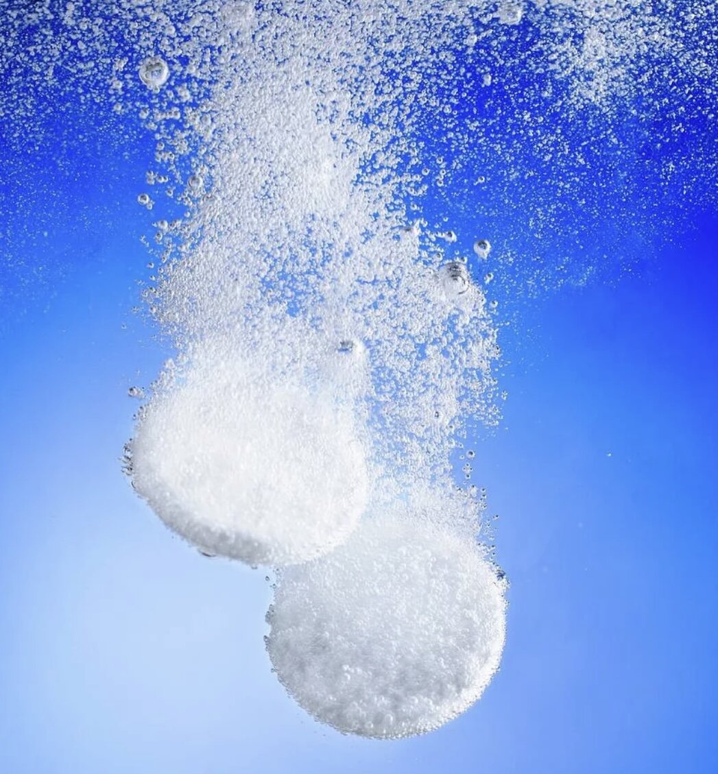 шипучие таблетки в воде. растворение в воде. шипучая таблетка в стакане с водой. шипучая таблетка растворяется в воде. шипучая таблетка в стакане.