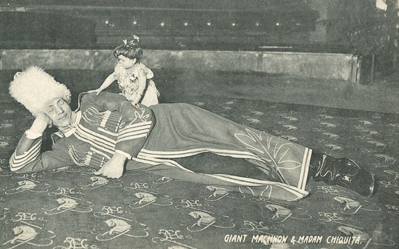 Сама фотография. Махнов лежит в странном костюме, на нём мадам Чикита.