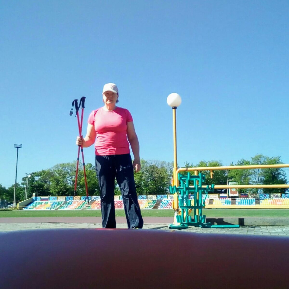 На стадионе со скандинавскими палками.