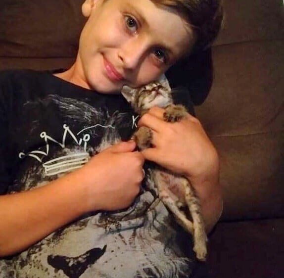 Парень с кошкой. Источник фото: https://koteiki.com/u-kotenka-otkazali-zadnie-lapki-i-tolko-devyatiletniy-malchik-pridumal-kak-emu-pomoch/