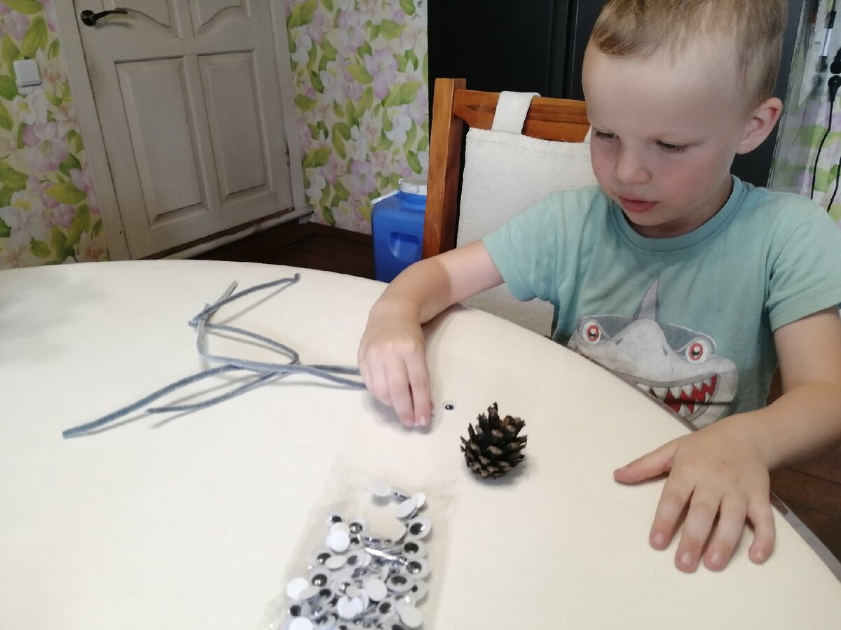 Сосредоточенный сын считает нужное количество деталей для паука