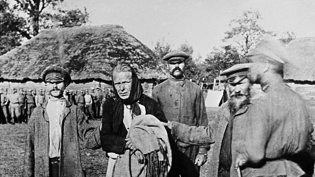    Немецкий шпион (2 слева) в женском платье, пойманный русскими крестьянами в прифронтовой полосе.© РИА Новости / Николай Пашин