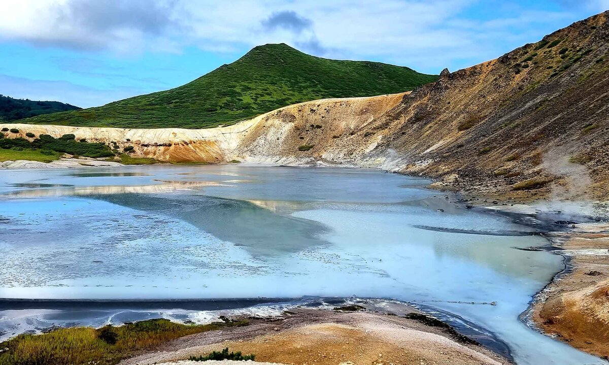 Во время ясной погоды вода озера Кипящее приобретает голубые тона, отзеркаливая небесную голубизну, как оазис на лунных просторах. Кальдера вулкана Головнина. Сентябрь здесь – еще лето. 06.09.2021.Автор фото: Боро Джукич.