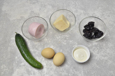 Как сделать салат Кролик с ветчиной и черносливом? Подготовьте продукты. Ветчину возьмите нежирную, натуральную, вкусную. Огурец — свежий, чернослив без косточек, сладкий. Яйца предварительно отварите и остудите. Морковь для украшения салата также отварите.