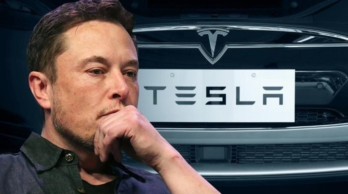 Илон Маск на фоне надписи "Tesla" 