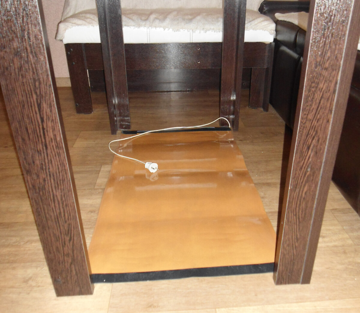 Размещение греющего коврика под столом, в месте частого пребывания