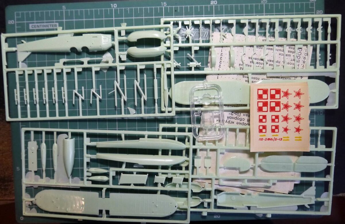 Старенький По-2 в масштабе 1:72 от НПО "Старт". Четко видны литнички из серого пластика, декалька, маленький литничок с прозрачными деталями а под всем этим добром инструкция.