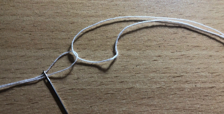 отрезаем  толстую нить нужной длины и один конец продеваем в образовавшуюся петлю тонкой нити