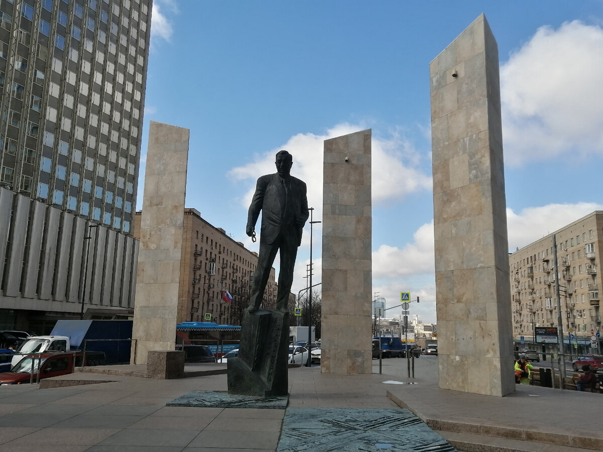 Слева - здание гостиницы "Золотое кольцо" (изначально -"Белград"), а за спиной Примакова - улица Смоленская, идущая в сторону Киевского вокзала. Апрель 2021 года, фото автора.