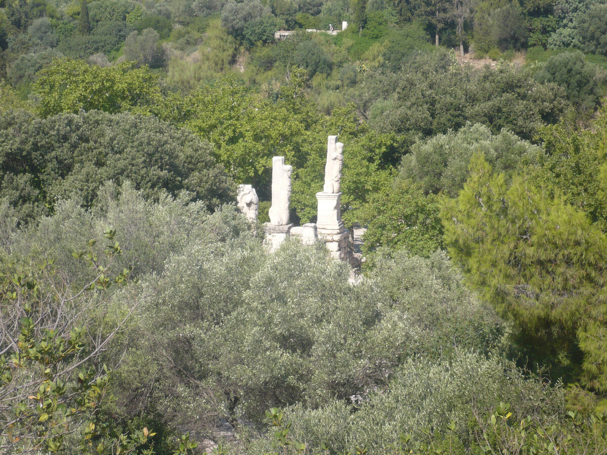 Руины храма, окруженные зелению вблизи афинского акрополя.