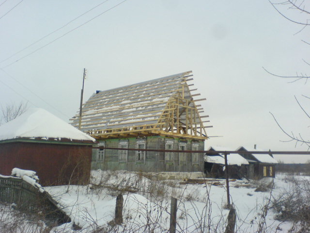 С дома снята фальцевая стальная кровля и стропильная конструкция скатного покрытия. А затем смонтирован каркас мансарды, накрытый гидроизоляционной  мембраной