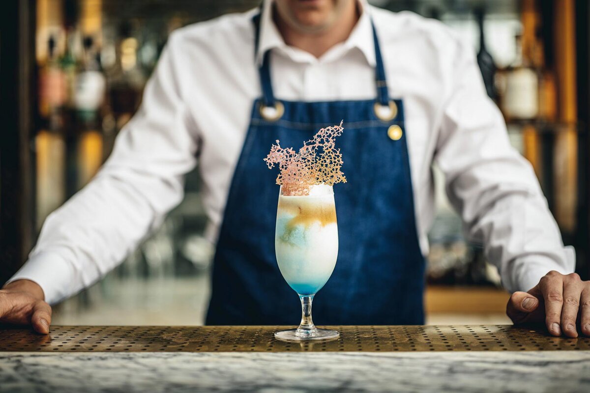 «Банановый кекс 1933» – намек на маниакальные пекарские экзерсисы, царившие в 2020 году на кухнях и в британских соцсетях. Банальный банановый кекс – выпечка, доступная даже начинающей хозяйке. Бармены объединили в коктейле виски, херес, банановый ликер, специи, масло какао и ваниль. По вкусу он стал «жидким воспоминанием о локдауне».