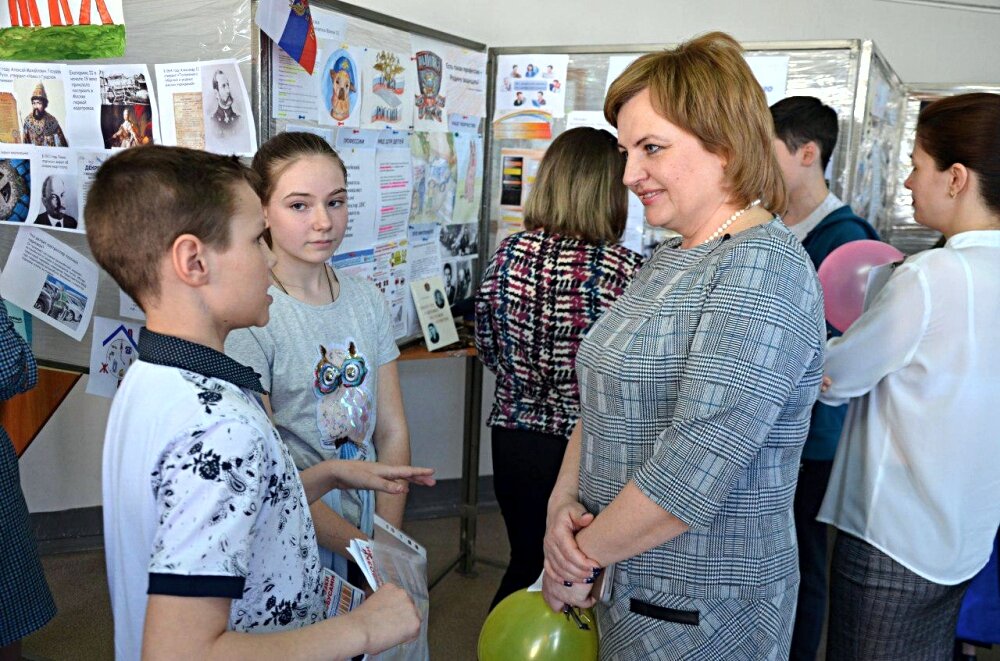 Директор нашей школы "валит" докладчиков у стендов на защите проектов классов. Вот прям загрызет их сейчас, правда?..