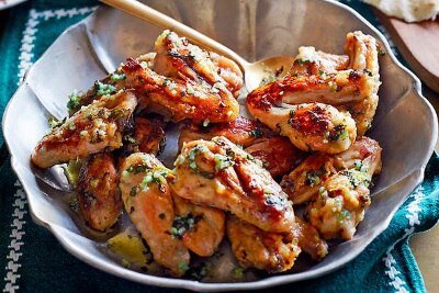 2 столовые ложки оливкового масла 
Для соуса
60 г мелко нарезанной петрушки
5 больших зубчиков чеснока (раздавить)
60 мл оливкового масла
2 столовые ложки лимонного сока

Разогреть духовку до 200 °C. Разложите крылышки на противень, полейте маслом и посолите. Жарьте примерно 45 минут. Прямо перед тем как достать уже из духовки, приготовьте соус. Нагрейте большую сковороду на слабом огне, добавите петрушку, чеснок и масло, и готовьте, помешивая, в течение 1 минуты. Добавьте лимонный сок и снимите с огня. Достать крылья из духовки, перемешать в сковороде с соусом.
Приятного аппетита!.