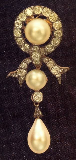 Брошь Марии Федоровны Романовой (при рождении Мария София Фредерика Дагмар). Брошь выполнена в виде бриллиантовой ленты, завязанной  бантом, который в центре украшен большой жемчужиной, имеет подвеску с двумя жемчужинами, одна из которых имеет форму капли. Весь жемчуг натуральный.