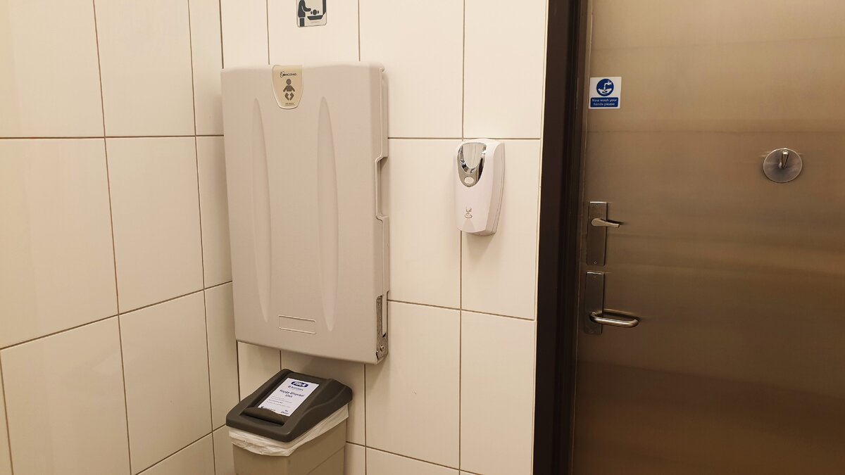 На стене выдвижной стол для пеленания детей. На двери - крючок для сумок