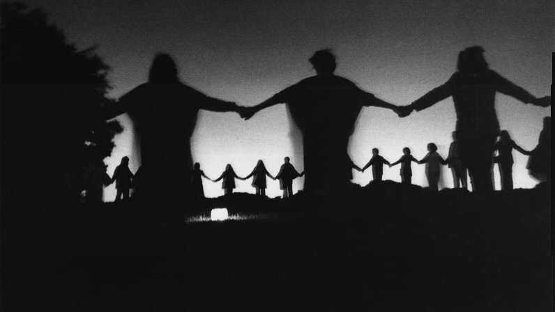 Современные друиды держатся за руки во время церемонии в Хэмпстед-Хит, на севере Лондона, 25 июня 1971 года.