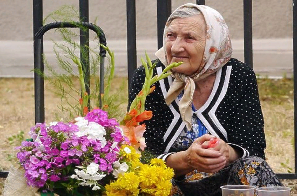 Бабушка цветочек. Старушка с цветами. Бабушка продает цветы. Бабушка на рынке цветы.