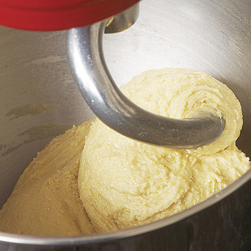 Смешайте муку, сахар, дрожжи, соль, яйца и молоко, пока тесто не станет твердым и эластичным.