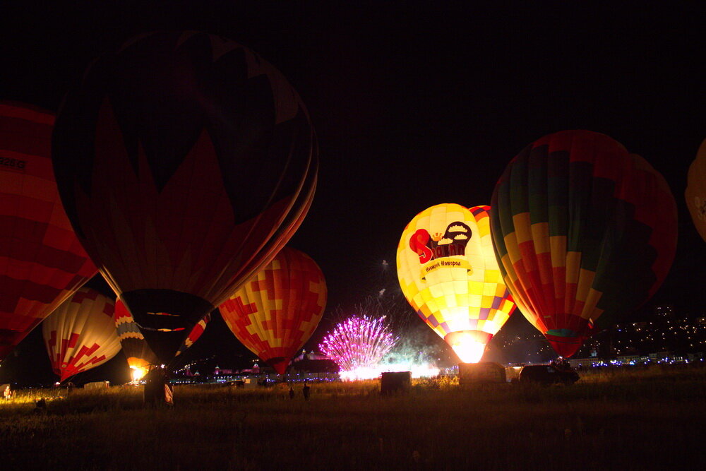 Они приехали, когда уже основательно смеркалось, и в свете фар начали готовить аэростаты к работе. По ночам полеты на них запрещены, но можно организовать ночное свечение – весьма эффектное и зрелищное мероприятие. Это был подарок воздухоплавателей на День Нижнего Новгорода. Погода внесла свои коррективы, под таким сильным ветром, до работы допустили только 10 шаров из 15, но в целом получилось очень круто.
