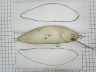 Отрезаем по размеру приманки кусочек скотча, прикладываем тело воблера к бумажной основе скотча, обводим приманку по контуру и вырезаем.