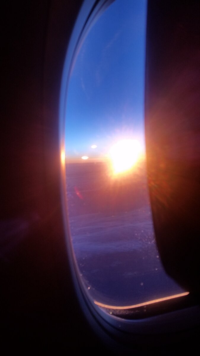 Вид из самолета на восходящее солнце