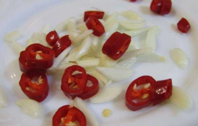 Чеснок порезать тонкими пластинками, горький перчик колечками.
