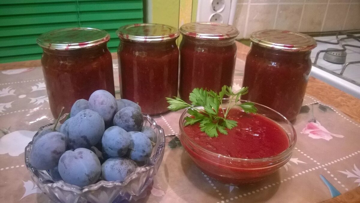 Ингредиенты
Слива 2000 г
Чеснок 200 г
Перец красный чили по вкусу
Перец болгарский 1000 г
Укроп
Петрушка
Базилик свежий
Эстрагон (тархун)
Паста томатная 2 ст.л
Соль 2 ст.л
Сахар 80 г
Перец черный молотый 1,25 г
Кориандр 1,25 г
Гвоздика 1.25 г
Тмин по вкусу
Чеснок очистить, вымыть, обсушить.  Сливу вымыть, удалить косточки.  Сладкий и горький перец вымыть, у сладкого перца удалить семена, нарезать на четвертинки.

Зелень вымыть, обсушить. У тархуна (эстрагона) оборвать листочки и молодые веточки.  Пропустить через мясорубку в отдельную миску чеснок.

Затем пропустить через мясорубку сливу, сладкий и горький перец, всю зелень, сложить пюре в металлическую кастрюлю с толстым дном.  Добавить соль и сахар по вкусу, молотые специи, хорошо перемешать и поставить на средний огонь.

Довести смесь до кипения, убавить огонь до минимального и варить 15–20 минут.  Затем добавить чеснок и кипятить ещë около 5 минут.

Разлить аджику в сухие стерильные банки и герметично закрыть стерильными сухими крышками. Банки перевернуть вверх дном, укутать и дать полностью остыть.

Хранить аджику в темном прохладном сухом месте.

Приятного аппетита!