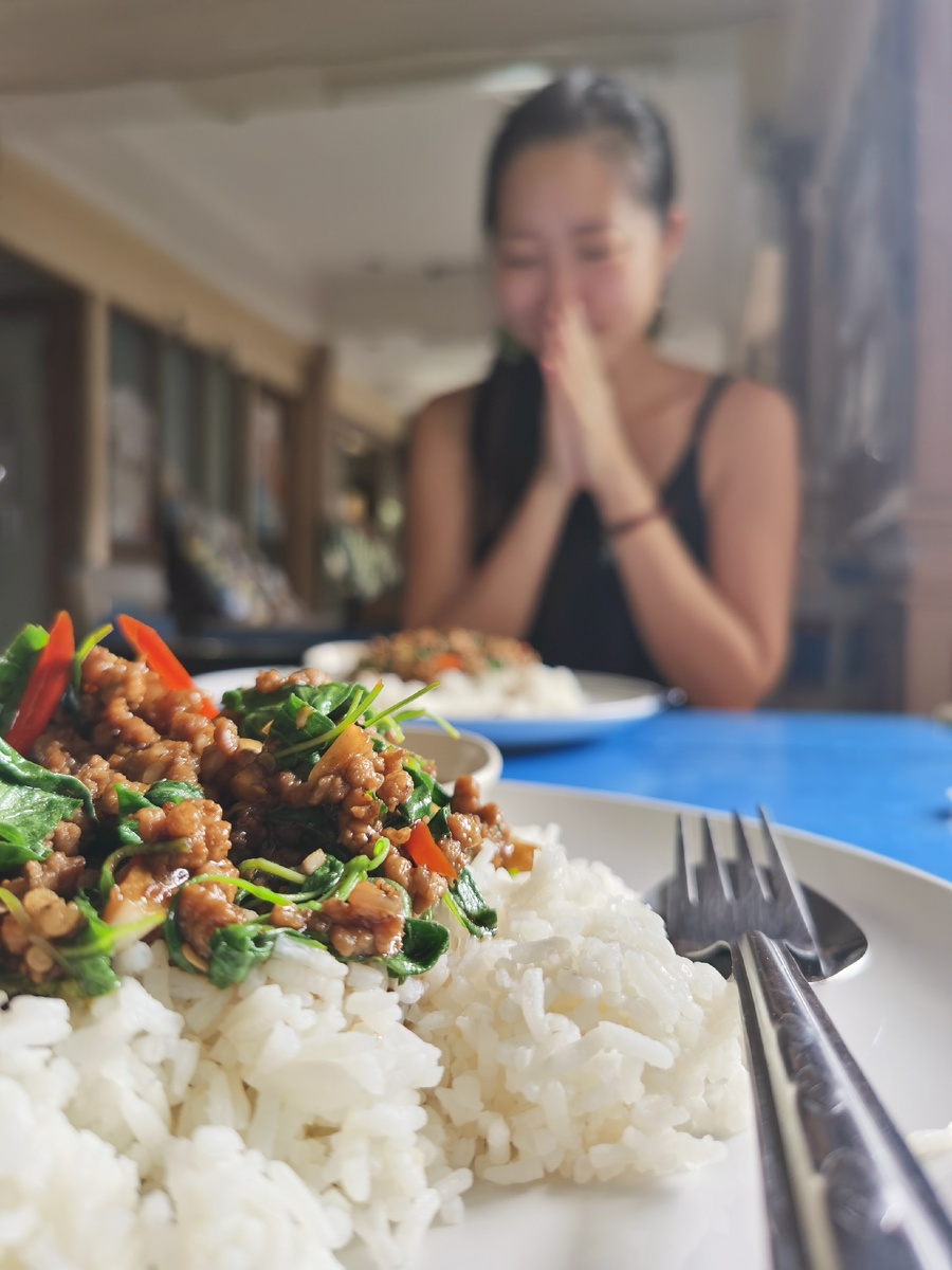 Рис с мясом и базиликом по-тайски, и Харука на заднем плане. Этот жест - что-то вроде нашего "приятного аппетита".