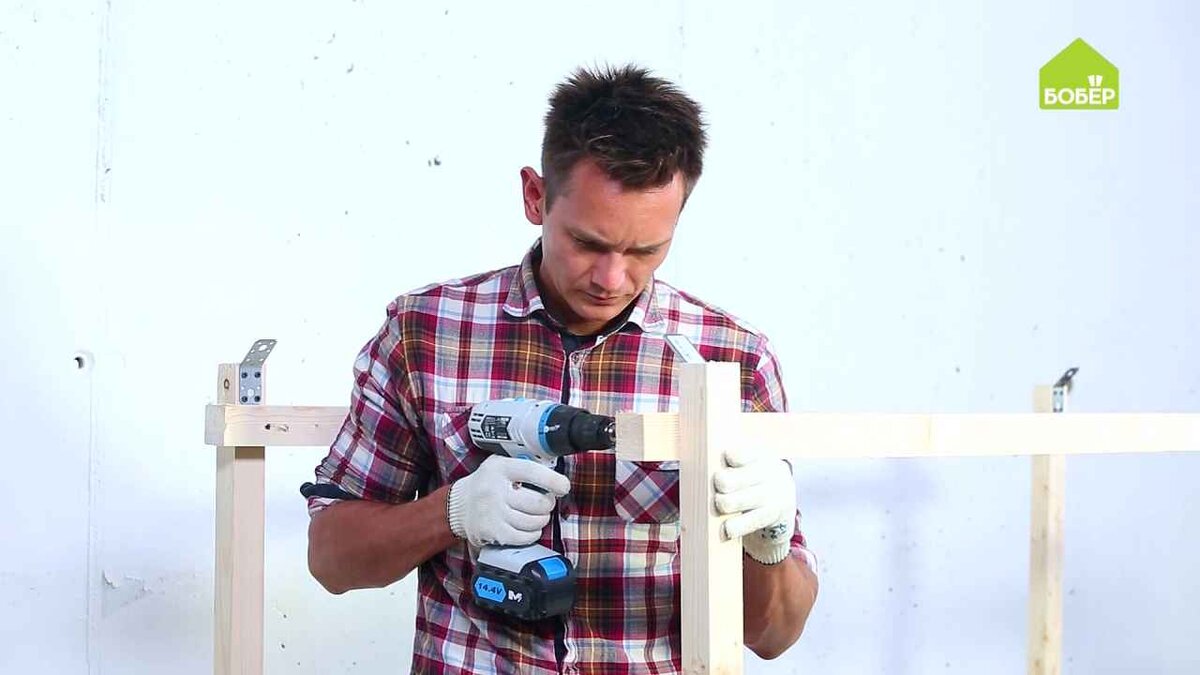 Разметьте и отпилите 2 верхние горизонтальные перекладины и прикрепите их к каркасу при помощи уголков и саморезов.