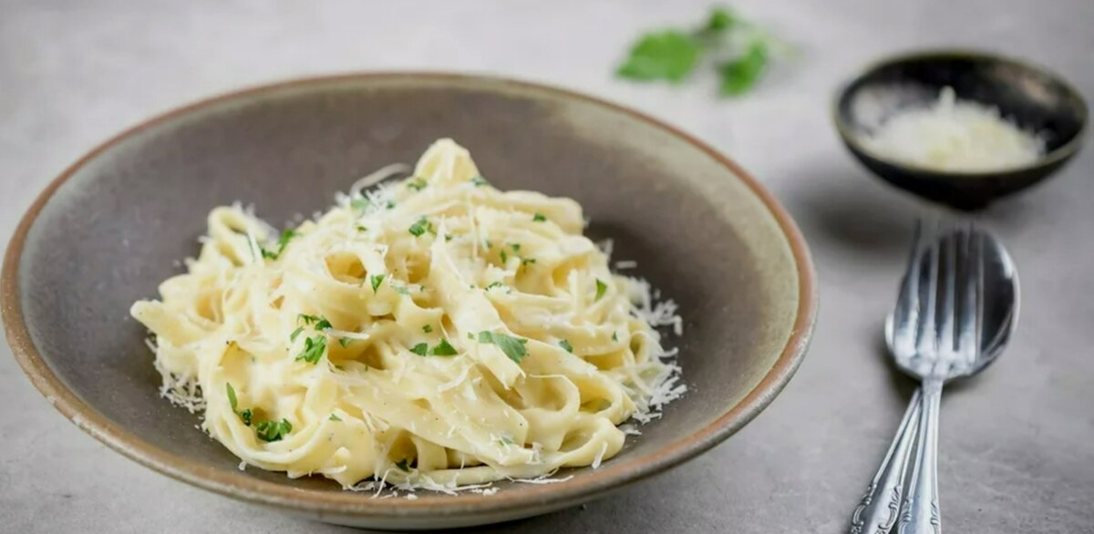 Этот классический фетучини Альфредо готовится со сливками, сливочным маслом, сыром Пармезан и петрушкой. 