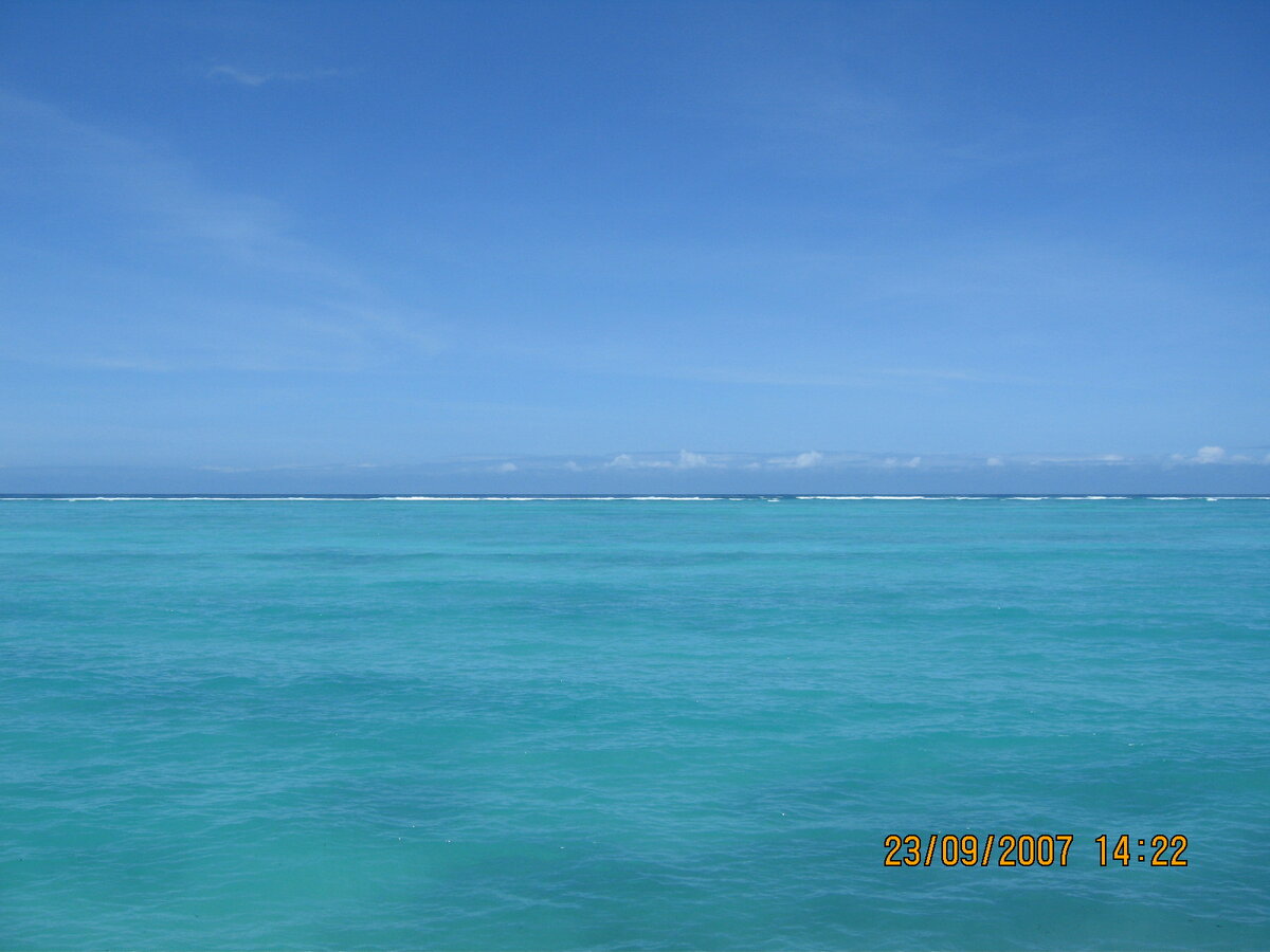 Голубое небо и зеленоватую воду разделяет коралловый риф, к которому во время отлива можно дойти "аки посуху". Занзибар.