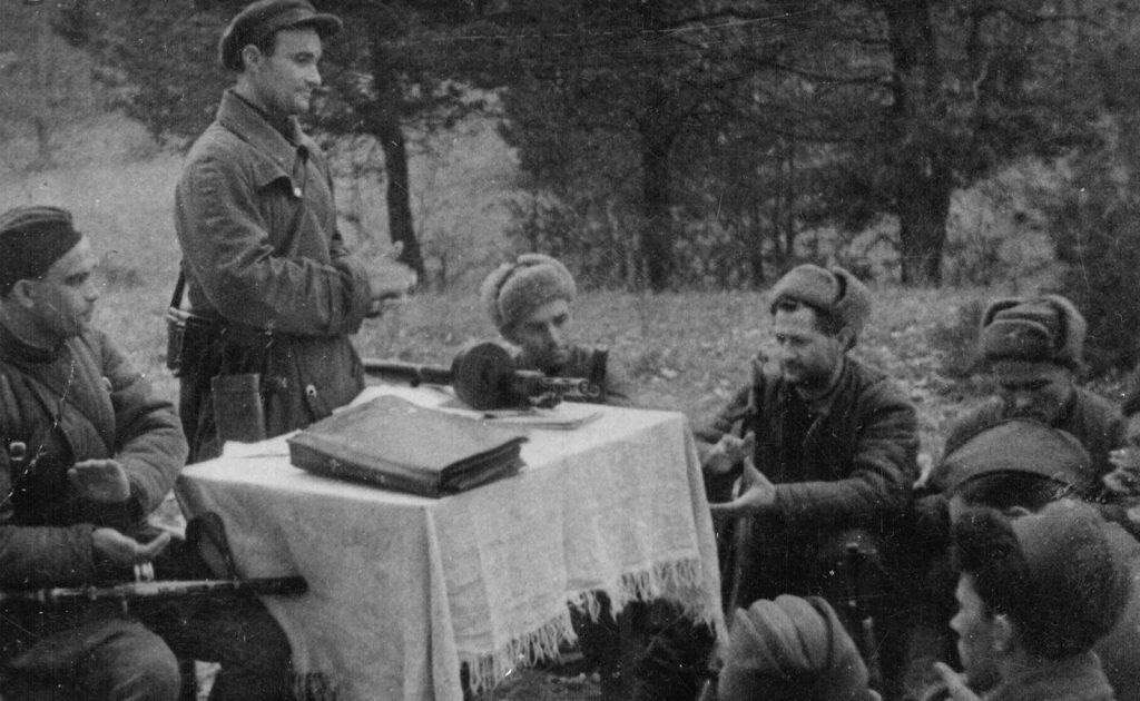Фотография военных лет. Солдаты в лесу у стола с папкой документов