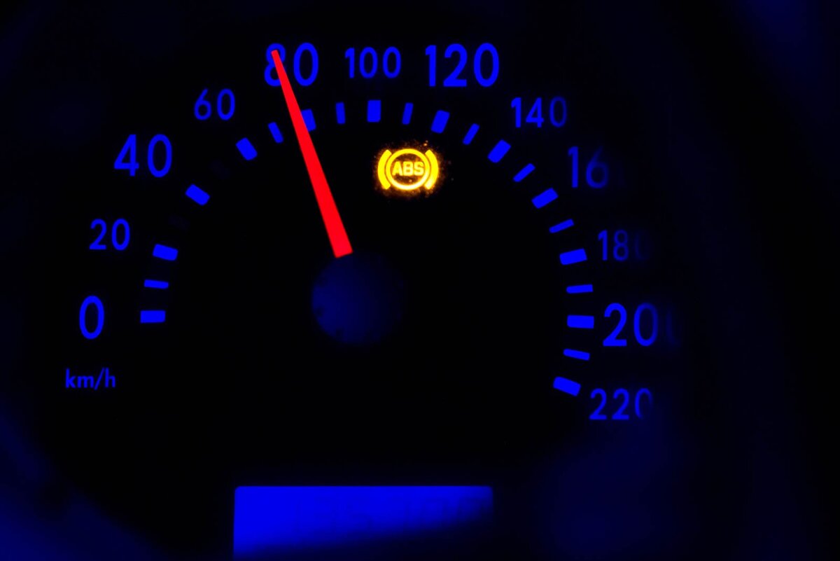 Диски и колодки
Самые очевидные вещи, про которые помнят все, – это состояние колодок и дисков. Что ж, об их состоянии действительно важно знать хотя бы для собственной безопасности. Торговаться из-за колодок не всегда получается: всё-таки это расходник. Хотя, конечно, не всегда дешёвый. А вот торговаться из-за дисков – это дело святое. Итак, смотрим.
Если машина на штампованных дисках, что-то увидеть трудно. Так что следующие советы больше подойдут тем, кто покупает машину на литых или кованных дисках.Критический остаток колодок, при котором можно начинать топать ногами и пытаться скинуть хотя бы две тысячи рублей, – около пяти миллиметров. Колодки своё доживают, и их действительно придётся скоро менять.Конечно, если колодки снять, можно увидеть что-то более интересное. Например, закисший суппорт. Но мы договорились ничего не разбирать, так что остаётся надеяться, что получится разглядеть остаток колодок сквозь диск. Если очень хочется, можно залезть под машину и посмотреть на диск с колодками изнутри. Тоже выход, тем более что машину снизу перед покупкой смотреть всё-таки придётся. Правда, делать это лучше на подъёмнике, а не лёжа на пузе.Ну а если вы машину продаёте, а не покупаете, то обратите внимание: неопытные покупатели при виде штампов про диски с колодками забывают. Ни на что не намекаю, просто для информации.
Гораздо важнее оценить состояние дисков. Они стоят дороже, так что тут поторговаться можно.Износ диска может быть разным. Для начала стоит провести по нему пальцем. Вряд ли диск будет совсем гладким, и некоторая выработка – это абсолютно нормально. Нам важно узнать, насколько это выработка большая. Для этого нужно понять, есть ли на краю диска кромка. Если она едва заметна – хорошо. Если же бортик вырос уже до нескольких миллиметров – диск лучше менять. Или хотя бы настойчиво торговаться, потому что проблема действительно имеет место быть. Особо упоротые люди могут носить с собой штангенциркуль. С помощью линейки глубиномера теоретически можно измерить высоту бортика и прикинуть износ диска. Но сделать это довольно трудно: подлезть часто невозможно, ровно поставить штангенциркуль тоже. Лучше для этого подходит, конечно, микрометр, которым можно легко и точно измерить изношенную часть диска и сравнить её с заводским параметром нового диска. Но от этого способа уже попахивает техническим и душевным занудством, так что подробно на нём останавливаться не будем. Да и опять же надо снимать колесо, а мы договорились этого не делать.А вот другая неисправность намного более хитрая, и глазами её увидеть практически невозможно. Речь идёт о диске, который в процессе эксплуатации «повело». В этом случае нарушается его геометрия, которую в сервисах определяют специальными инструментами. Говорят, кое-кто способен увидеть такое биение диска, прокручивая поддомкраченное колесо и глядя через какой-нибудь зазор, который должен быть ориентиром. Честно говоря, я этот способ не проверял и в его действенность не верю. Чтобы диск бил в педаль, достаточно десятых долей миллиметра. Увидеть их глазом невозможно. Так же, как и пытаться определить биение по звуку приставленной к диску отвёртки. Может быть, такие специалисты и существуют, но с подобными уникальными слухом и твёрдостью рук лучше закончить консерваторию и уйти в снайперы.Есть гораздо более простой способ определить поведённые диски: сесть за руль. Часто продавцы настаивают на том, что, мол, нет страховки, поэтому за руль он пустить не может. Однако при покупке машины обязательно нужно проехать именно за рулём. И дело не только в тормозах. Могу вспомнить собственный опыт покупки Мазды 6. Машина и внешне, и на ходу казалась прекрасной. И только сев за руль, я понял, что она серьёзно страдает врождённой болезнью рулевой рейки. Точнее, втулки датчика ЭУР, которая изнашивается, отчего машина хочет ездить кругами. При повороте в одну сторону руль крутится легче, чем в другую. Такое на «шестёрках» бывает часто, лечится не слишком дёшево, а заметить это можно, только сидя за рулём. Так что ездить перед покупкой надо обязательно. Но вернёмся к нашим тормозным дискам.
«Поплывший» диск можно заметить на ходу. В зависимости от степени его кривизны симптомы могут либо проявляться частично, либо всем своим разнообразием одновременно. К симптомам можно отнести следующее: неравномерное замедление (волнообразное), биение педали тормоза, вибрацию педали при торможении на большой скорости, небольшие передвижения педали тормоза вверх-вниз, которые наиболее заметны перед окончательной остановкой. Если есть хотя бы один из признаков, можно начинать торг.Теоретически диск не всегда нужно сразу менять. Если он ещё не слишком сильно изношен (бортик на его краю не слишком большой или его нет вовсе), диск вполне можно проточить. Это дешевле, чем покупка нового диска. Но если ваша цель – сбросить цену машины, то настаивайте на необходимости покупки новых дисков. Особенное, если диск заметно изношен.Ну и ещё одно замечание: немного похожие симптомы могут быть в случае некоторых других неисправностей. Например, при грыже на шине или неправильной балансировке колеса. Кривизна дисков вылезает только при нажатой педали тормоза.Тормозные магистрали
Почему-то многие забывают проверить тормозные трубки и шланги. А зря. На машинах возрастом лет эдак от десяти трубки вполне могут быть уже подпорчены коррозией. Их надо осмотреть, и если что – указать на их состояние продавцу.
Со шлангами тоже самое. На них не должно быть никаких подтёков тормозной жидкости, а что ещё более важное – никаких вздутий. И не стоит доверять глазам, лучше провести качественную пальпацию. И ещё будет неплохо проверить, не сильно ли распирает шланги при нажатии на педаль тормоза. Лучше это делать на машине с работающим двигателем (чтобы работал вакуумный усилитель) и помощником, который будет от души давить на тормоз, пока вы щупаете шланги.Ну а если они в запущенном состоянии, машину надо смотреть более тщательно: владелец, который не проверяет элементы тормозной системы, очень безбашенный человек.Педаль тормоза
Биение педали тормоза – это не единственная и не самая серьёзная неисправность тормозов, которую можно обнаружить во время поездки за рулём. Есть ещё две плохие «привычки» педали тормоза: слишком легко уходить в пол или наоборот вставать колом. Посмотрим, о чём говорит то или иное поведение педали.Причин для провала педали может быть несколько. Точнее, причина всегда одна – завоздушивание, но возникает она в разных ситуациях.Самая распространённая – это неисправность главного тормозного цилиндра. Со временем он изнашивается, изнашиваются и его стенки, и уплотнительные манжеты. Часто виноваты именно манжеты, и их можно заменить. Но диагностика ГТЦ – не дело для благородных донов, поэтому смело говорим о необходимости замены цилиндра и требуем скидку. Главное – цокать языком и закатывать глаза к небу.Завоздушивание может произойти и из-за трещин или дыр в магистрали. Те же микротрещины в шлангах или трубках могут привести к попаданию воздуха. Если вы помните из курса школьной физики, жидкость – штука несжимаемая. А воздух вполне сжимаемый, поэтому если его в системе нет, педаль ходит с правильным усилием, а если он есть – она проваливается до тех пор, пока воздух не сожмётся в достаточной мере.Иногда причиной провала педали становятся изношенные колодки. Но такое встречается редко.Ну и если вдруг вы купили машину с проваливающейся педалью тормоза, но с исправными магистралями, попробуйте на всякий случай прокачать тормоза с новой жидкостью. Возможно, предыдущий владелец по какой-то причине упустил уровень «тормозухи», завоздушил систему и не смог её нормально прокачать. А может быть, причина в гигроскопичности тормозной жидкости: если её не менять слишком долго, она впитывает влагу, которая при торможении испаряется. И это тоже становится причиной завоздушивания. В общем, заменить жидкость не помешает. Шансы не слишком большие, но это недорого, а на старых машинах бывает всякое.Виновником встающей колом педали обычно становится вакуумный усилитель. Разбираться в его неисправностях – это тема для отдельного материала, а тут скажем так: если педаль с трудом продавливается, торг может быть очень существенным. Для более полной диагностики можно поиграть педалью тормоза при заглушенном и запущенном моторе, что поможет определить неисправность клапана или мембраны. Но опять же: сегодня не об этом.Ещё один признак неисправного усилителя – проседание оборотов мотора в момент нажатия на педаль тормоза. И, наконец, если есть какие подозрения на работу вакуумника, послушайте, как он работает. Возможно, шипит какая-нибудь подходящая к нему трубка с ослабленным хомутом или трещиной.Что ещё?
Под капотом желательно проверить уровень тормозной жидкости в бачке. Заодно хотя бы внешне оценить её состояние. Если она чёрная – это плохо. Старая жидкость не только плохо работает, но и портит тормозную систему содержащейся в ней водой и механическими примесями от тормозных цилиндров. Да и вообще свидетельствует о свинском отношении продавца к своей машине.И обязательно надо проверить работу ABS. Конечно, диагностировать блок самостоятельно, скорее всего, не получится, но горящая лампочка – это плохо. И даже если лампа не горит, стоит хорошенько разогнаться и затормозить в пол до юза. Юза, само собой, быть не должно.Отказы ABS бывают по разным причинам. Если система не работает, продавец может успокоить. Мол, датчик глючит, ничего серьёзного. Однако на многих машинах датчик (кольцо или гребёнка) сделаны заодно со ступицей, и менять их будет довольно дорого. А на некоторых машинах это вообще слабый узел. Например, на некоторых Кадиллаках.Не стоит забывать, что ABS – это часть системы курсовой стабилизации. Если не работает ABS, то не работает и стабилизация. Так что поломка копеечного датчика (который иногда не копеечный) приводит к довольно существенным последствиям, иногда – дорогим в устранении.