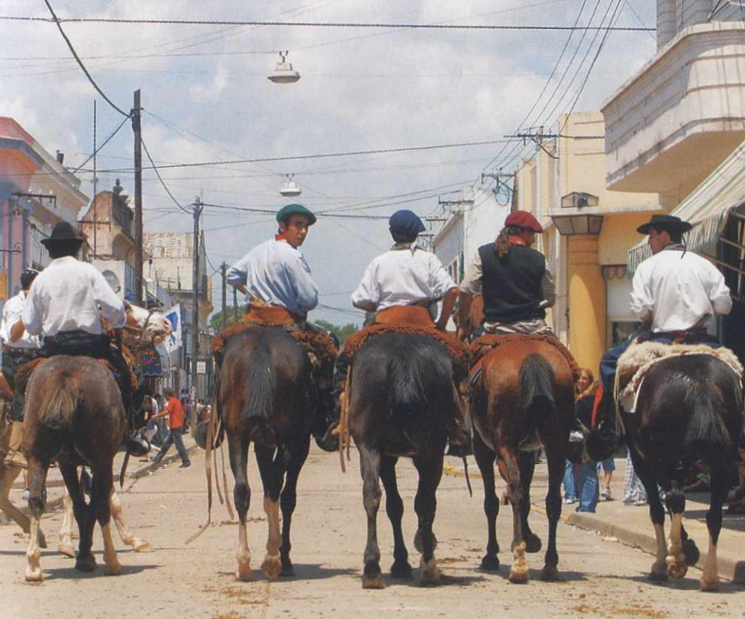 Гаучо, въезжающие в Сан-Антонио-де-Ареко во время ноябрьского фестиваля.