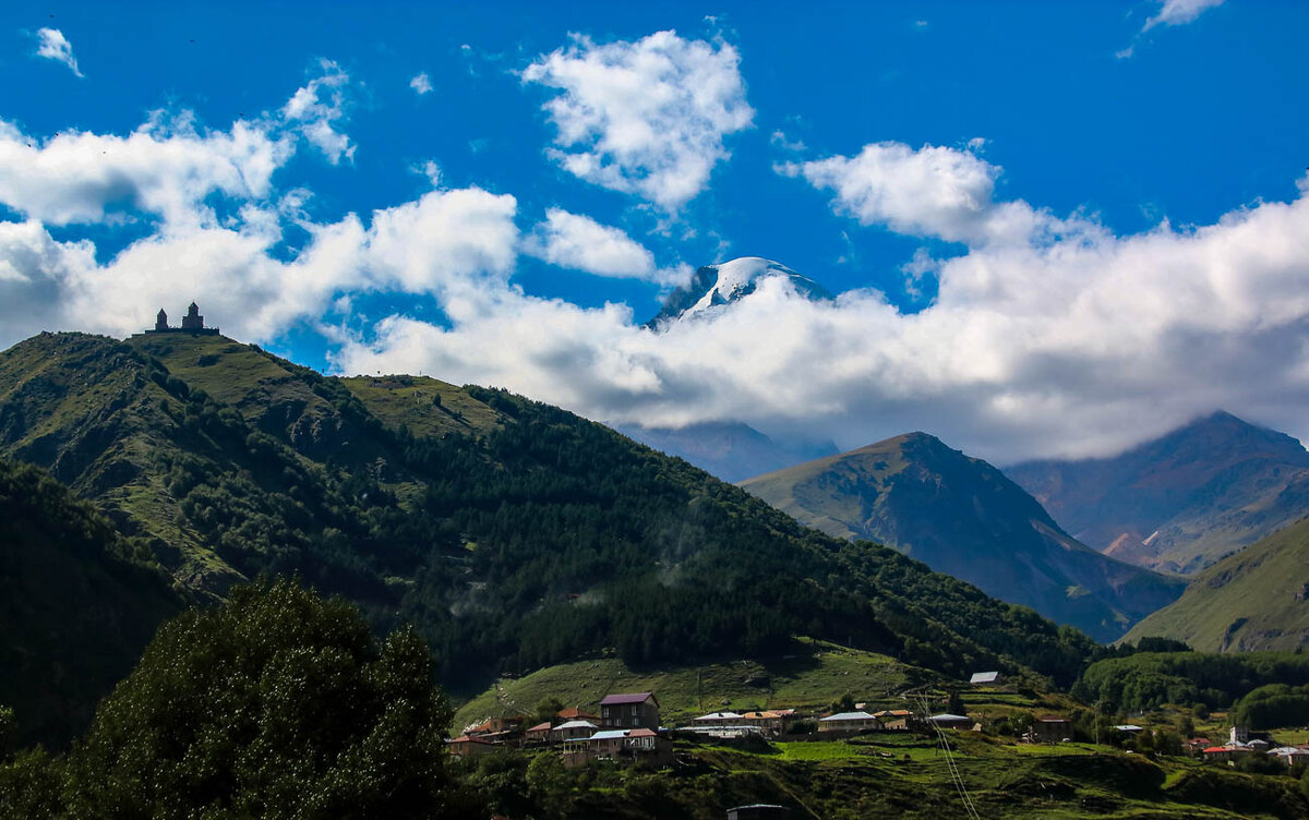 Видно верхушку горы Казбек и Троицкую церковь.