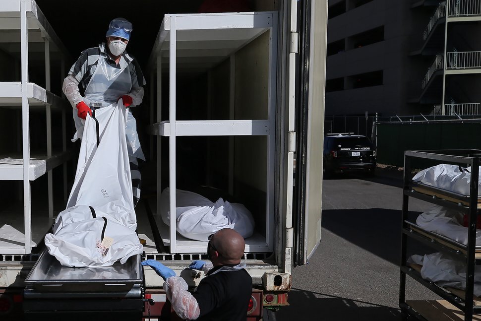 Заключенный из следственного изолятора округа Эль-Пасо загружает тела, завернутые в пластик, в рефрижераторный трейлер временного морга на стоянке Бюро судебно-медицинской экспертизы округа Эль-Пасо, 17 ноября 2020 года, в Эль-Пасо, штат Техас. COVID-19 возродился с удвоенной силой: в течение последних нескольких недель в Соединенных Штатах в среднем регистрировалось более 150 000 новых случаев заболевания в день, что более чем вдвое превышает уровень заражения в октябре. В Южной Дакоте в среднем на 100 000 жителей приходится около трех смертей, Чикаго объявил о новой 30-дневной изоляции, а Нью – Йорк, чье восстановление после разрушительной ранней вспышки болезни рассматривалось как образец, объявил, что школы снова закроются. 
[ См.: последние новости о вспышке коронавируса ]
Одним из наиболее пострадавших городов в последние недели стал Эль-Пасо, штат Техас. В период с 9 по 22 ноября в округе Эль - Пасо с населением 840 000 человек было зарегистрировано более 19 000 случаев заболевания. В настоящее время в округе зарегистрировано около 1000 случаев смерти от этого вируса, что является одним из самых высоких показателей смертности в стране. Распространение также вызвало политическое столкновение с высокими ставками: в конце октября, когда местные дела обострились, высшее должностное лицо округа, окружной судья Рикардо Саманиего, издал местный приказ о закрытии только Поскольку число погибших растет, Крис Лухан, директор похоронного бюро в Эль-Пасо с похоронными бюро Sunset, обеспокоен тем, что празднование Дня Благодарения может еще больше усугубить кризис. "Я думаю, что все в сообществе прямо сейчас находятся в крайней нужде, и мы все как бы скрещиваем пальцы и молимся, чтобы люди не собирались в этот день благодарения", - говорит он. 
Мы встретились с Луханом в его офисе в конце ноября. Это интервью было отредактировано для большей полноты и ясности.

Как прошли последние несколько недель в похоронном бюро?

Это очень печально, потому что мы видим людей, которые не должны уходить из жизни, к сожалению, уходя из жизни. Вы видите здоровых людей, вы видите семьи, с которыми мы разговаривали, которые были такими: "вы знаете, мы только что были в Руидосо [Нью-Мексико] на прошлой неделе верхом, а через три дня он ушел". Мы знаем, в какой отрасли мы находимся, но я не думаю, что кто-то хочет видеть, как проходит так много людейСколько услуг вы оказываете сейчас по сравнению с тем, что было несколько месяцев назад или год назад? 
Прямо сейчас мы проводим от четырех до пяти похорон в день, по сравнению с тем, где мы делали, может быть, один или два. Обычно мы всегда стараемся провести хотя бы одни похороны, максимум-два, но, например, в субботу у нас было шесть похорон.

Сейчас стало так плохо, что мы фактически поставили наши лимузины на хранение и арендовали дополнительные катафалки, чтобы мы могли идти вперед и иметь возможность разместить все семьи, которые мы обслуживаем. Мы добавили три больших холодильных установки просто для того, чтобы быть активными в течение этого времени, потому что мы просто не знали, когда эта пандемия закончится.

С точки зрения логистики, со сколькими из них вы можете справиться? Могли бы вы справиться с большим количеством похорон, если бы это было необходимо, или вы правы на пределе?

Мы добавили больше персонала, чтобы помочь нашим похоронным директорам и бальзамировщикам. Мы сделали это тоже, так что мы можем идти вперед и принимать все услуги, которые у нас есть. Я просто не хочу быть дома. 