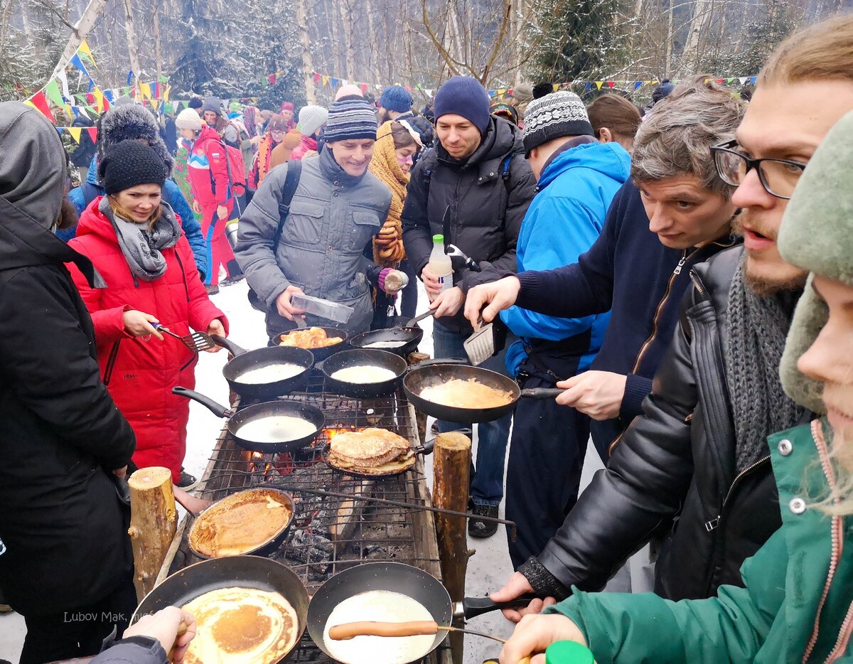 Народ сам накрывает импровизированные столы по краю поляны.